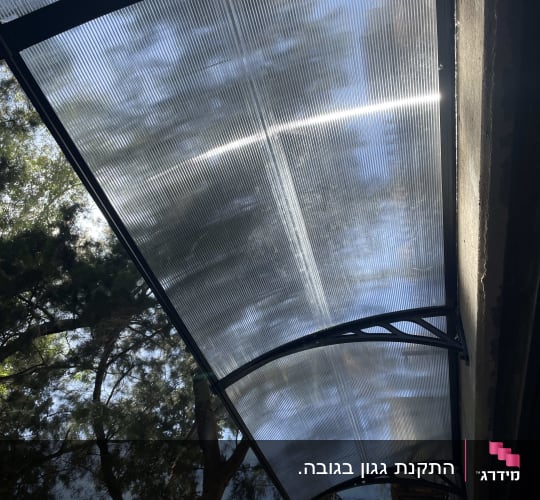 גג פלסטיק שקוף עם קורות מתכת תומכות